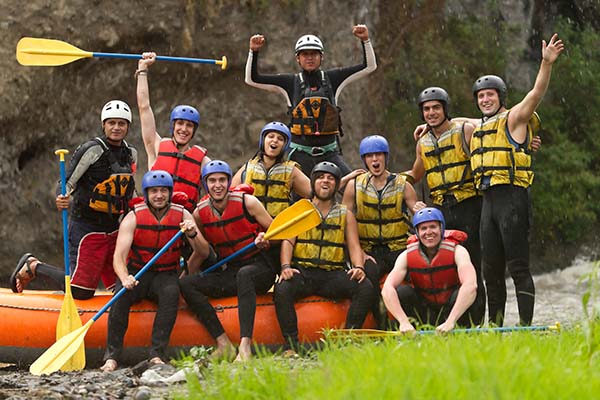 a group of male rafters celebrating a trip of a thrilling rafting adventure
